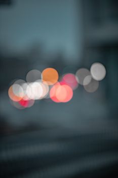 Vibrant bokeh lights create an abstract pattern in a night scene, offering a sense of mystery and intrigue.