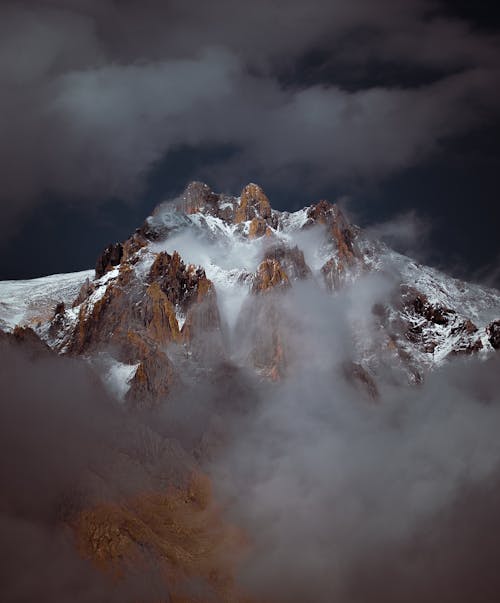 Snow Covered Mountain Under Cloudy Sky