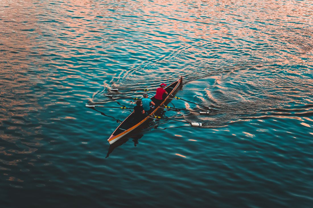 A rowing crew pulling together on open water, photo by Adrian Jozefowicz on Pexels