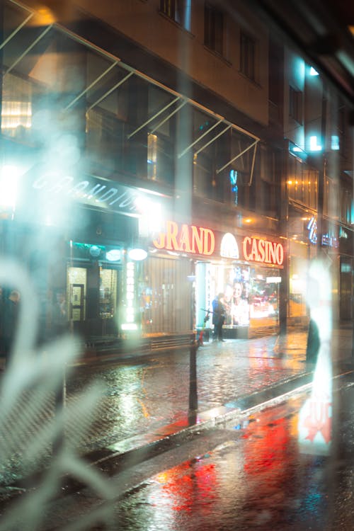 Person Standing outside a Casino on a Rainy Night