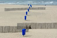 Blue Trash Bins on Shore