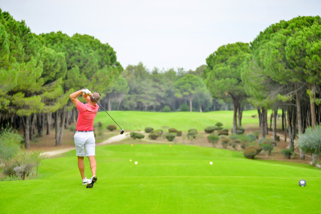 Free Man in Red Top Playing Golf Stock Photo
