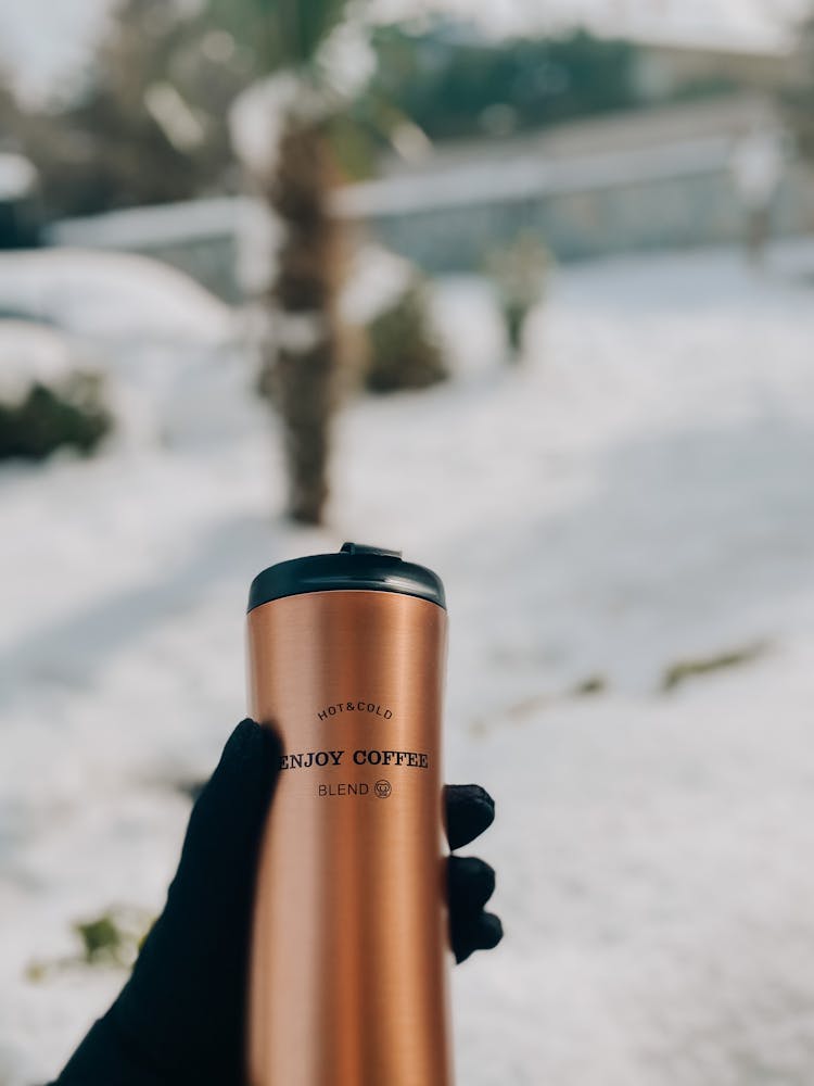 A Person Holding A Thermal Jug