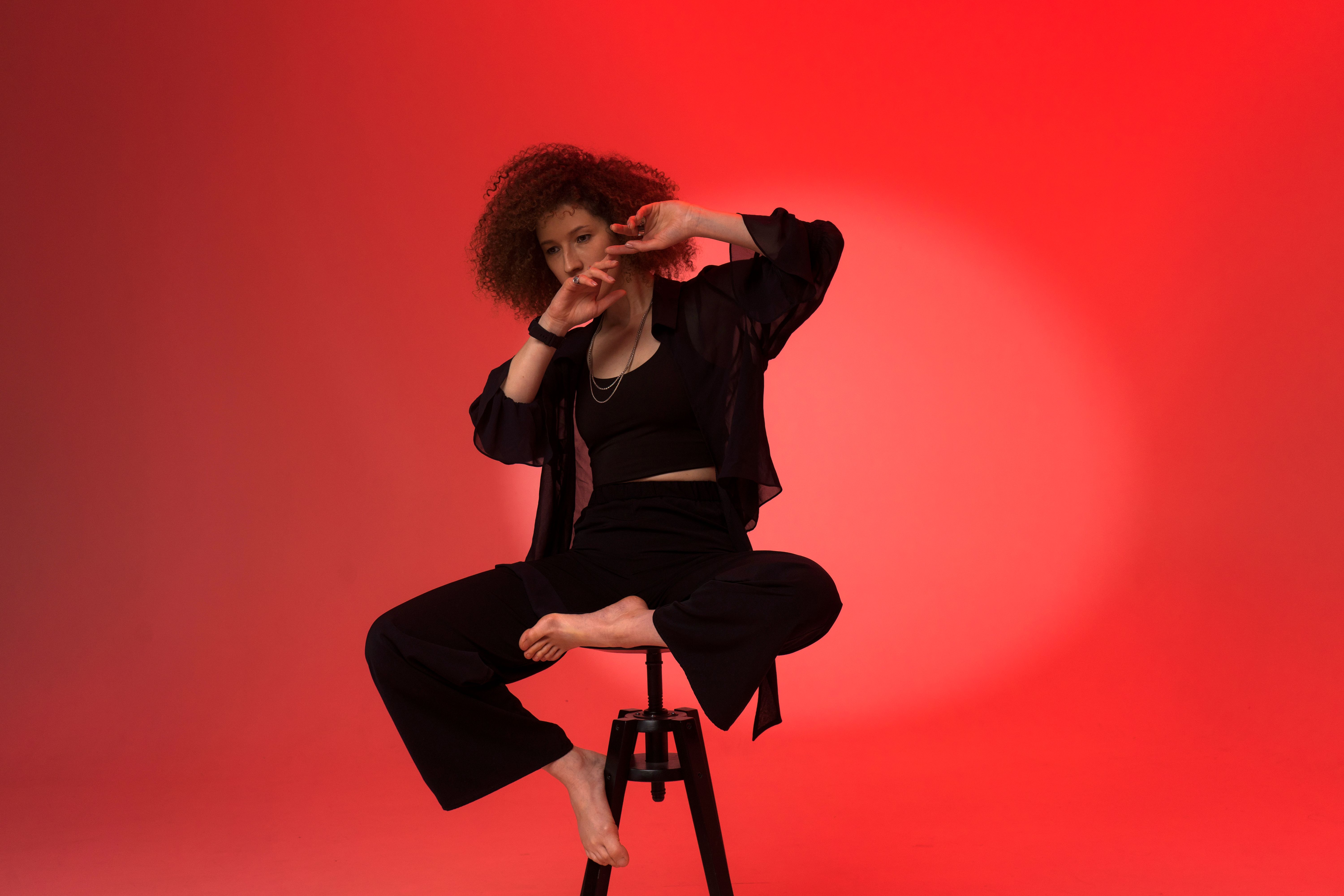 Woman in Black Blazer Sitting on a Chair while Posing at the Camera ...