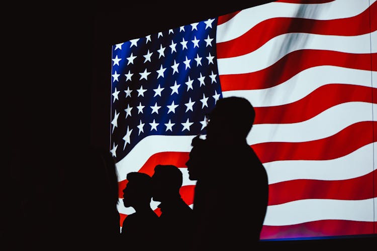 Silhouette Of Four Person With Flag Of United States Background