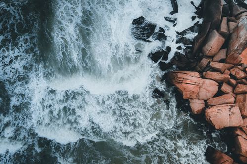 Free A stunning aerial view of waves crashing on the rocky coast of Kijal, Terengganu, Malaysia. Stock Photo