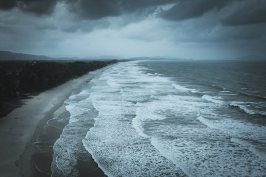A dramatic aerial view of Kijal Beach in Terengganu, Malaysia under cloudy skies.