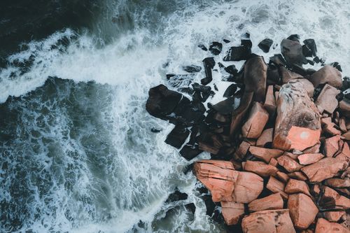 Free Captivating aerial shot of crashing waves against a rocky shoreline in Kijal, Terengganu. Stock Photo