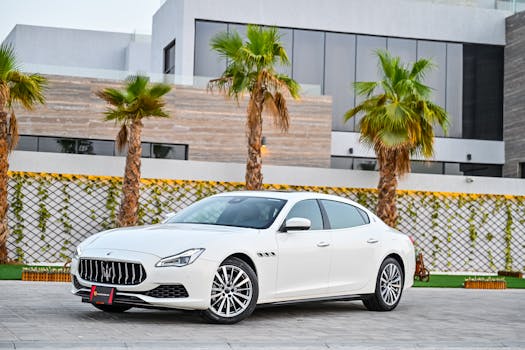 A white Maserati parked outdoors in the UAE with palm trees in the background.
