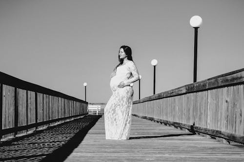 Foto En Escala De Grises De Una Mujer Embarazada Con Un Vestido Maxi