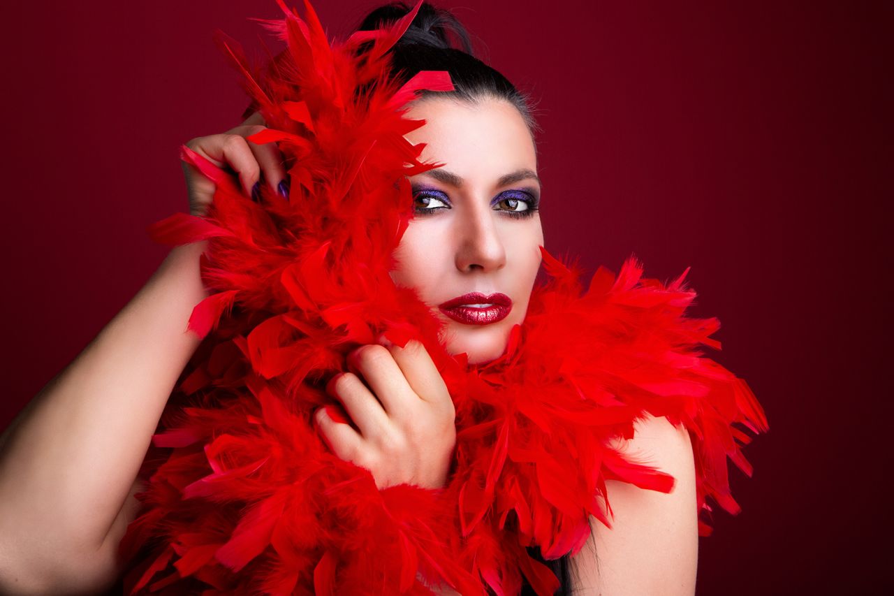 stylish portrait of a woman wrapped in a vibrant red feather boa showc