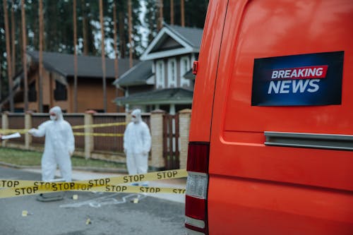 People Wearing Personal Protective Equipment Standing in the Crime Scene