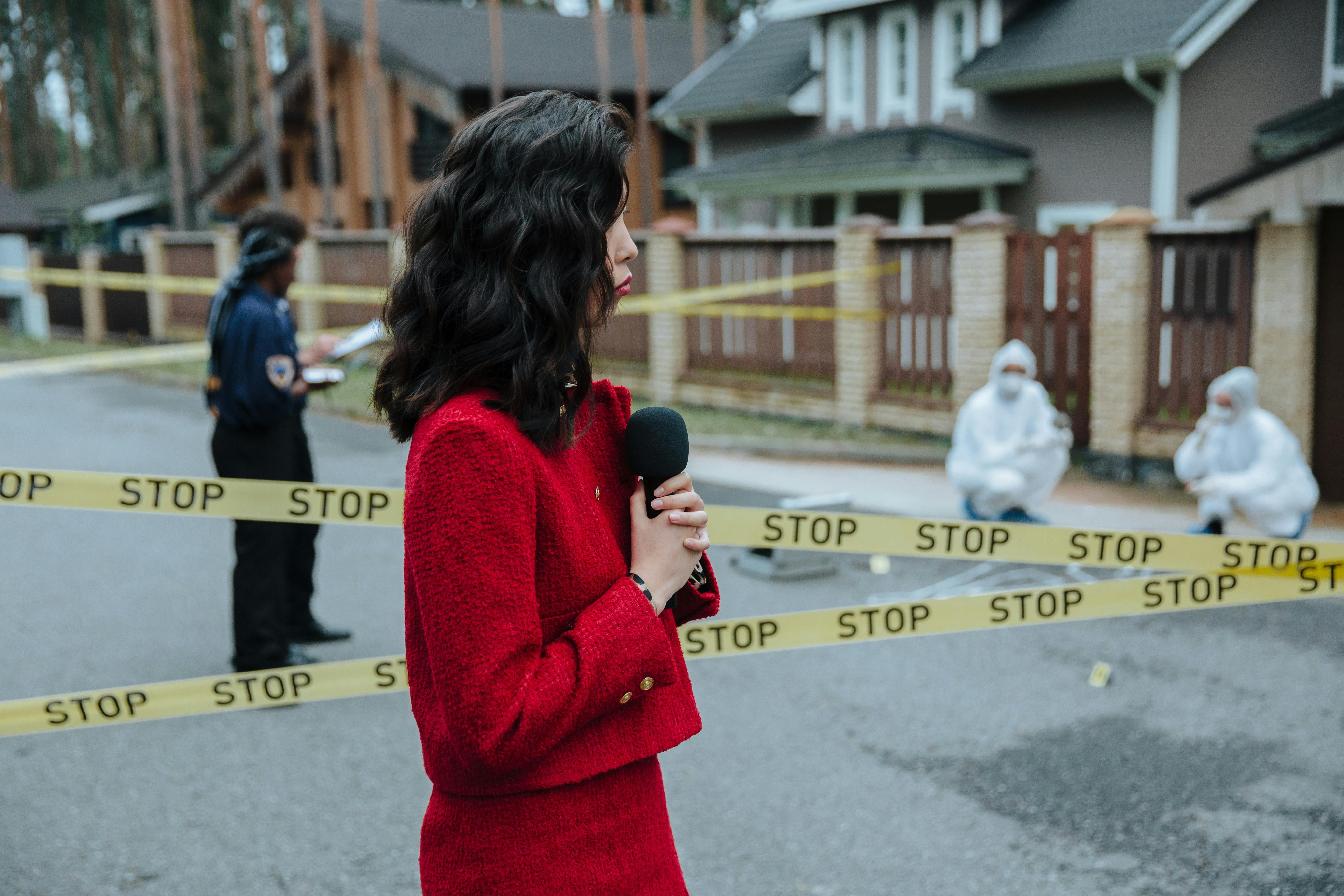 woman in red blazer holding a microphone