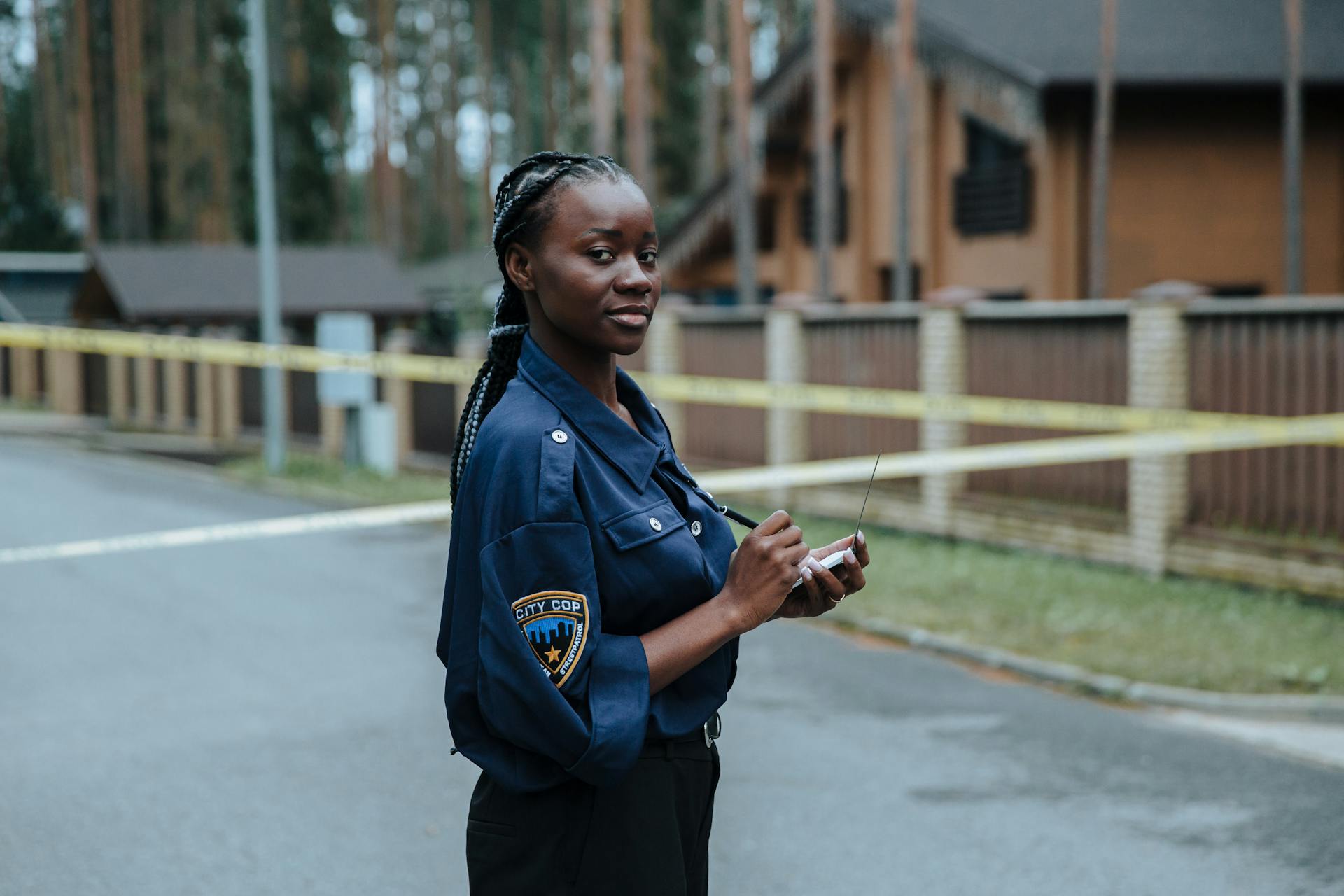 A Police Officer Standing in the Crime Scene while Looking at the Camera