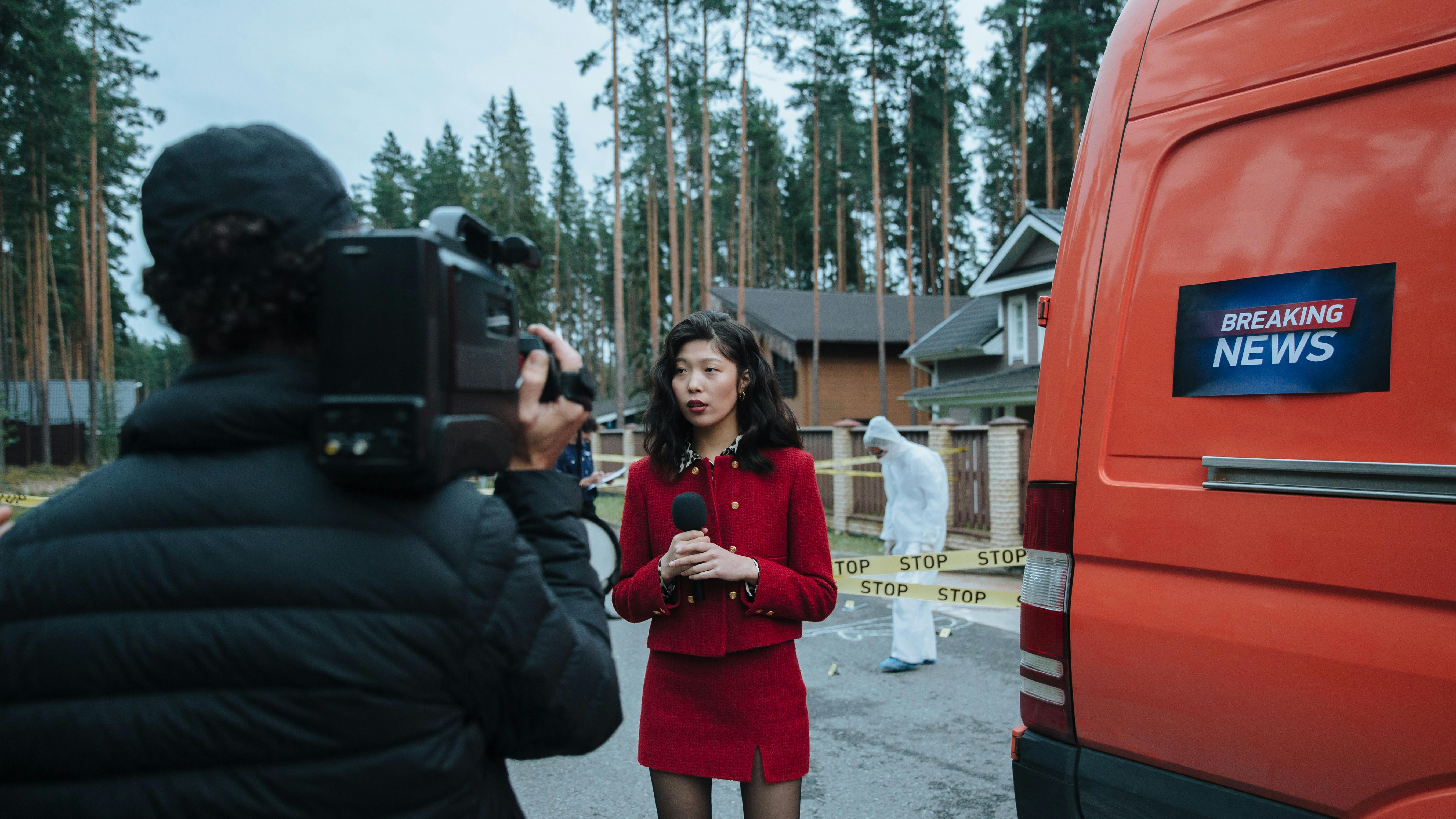 woman in red long sleeve shirt standing beside orange vehicle