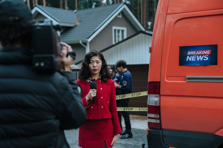 A Woman Reporting Beside The Van 