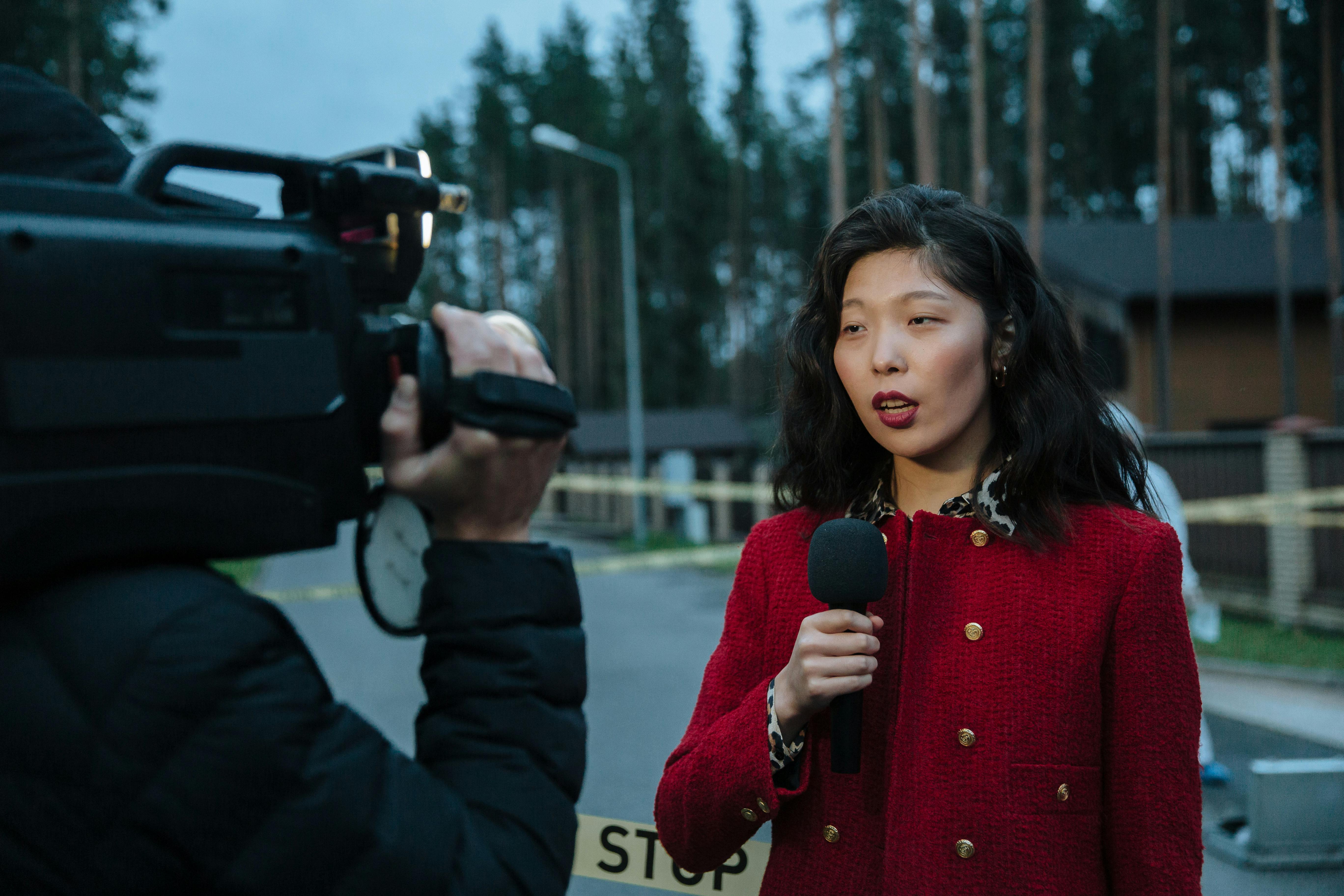 woman in red and black sweater holding black camera