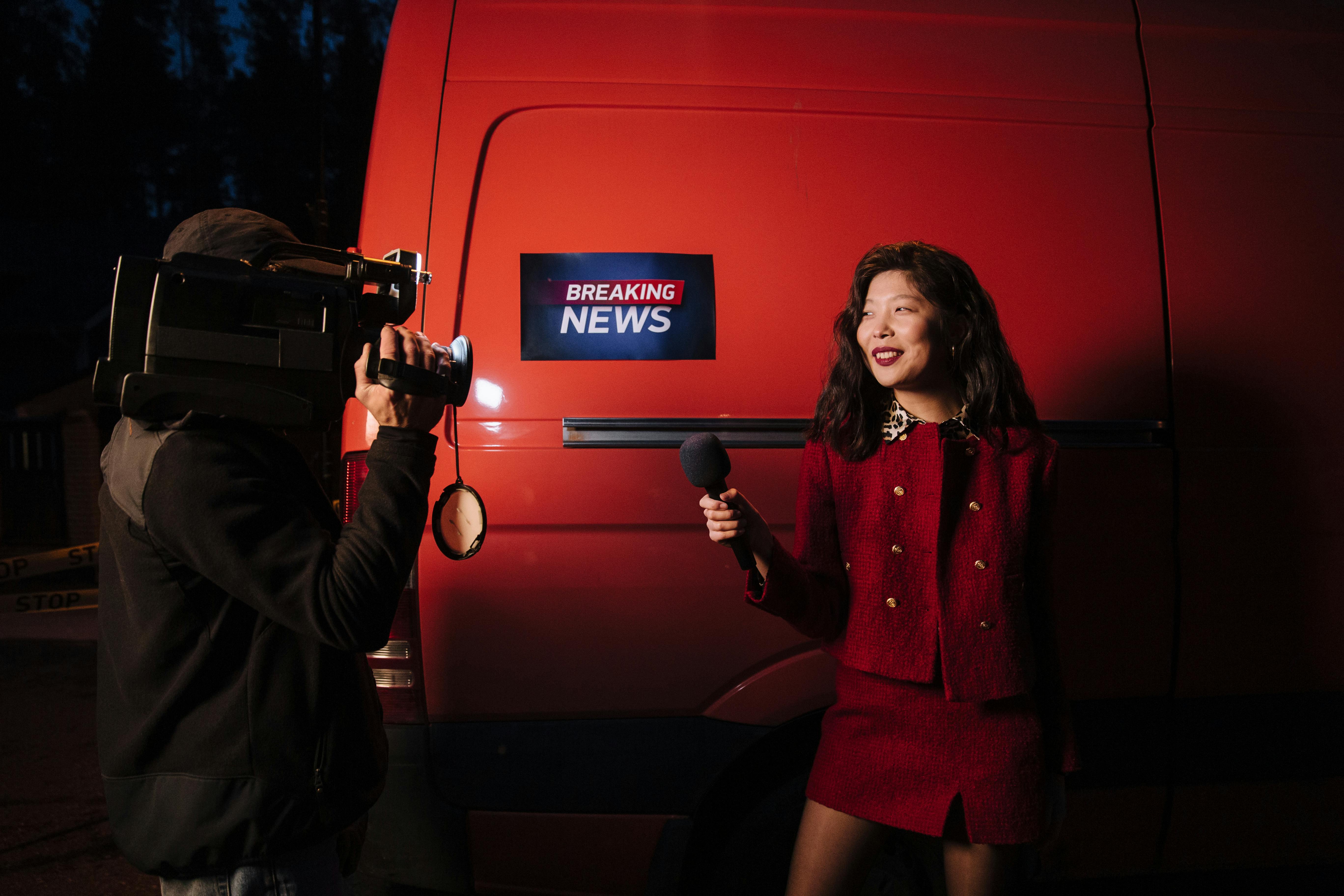 reporter against red car