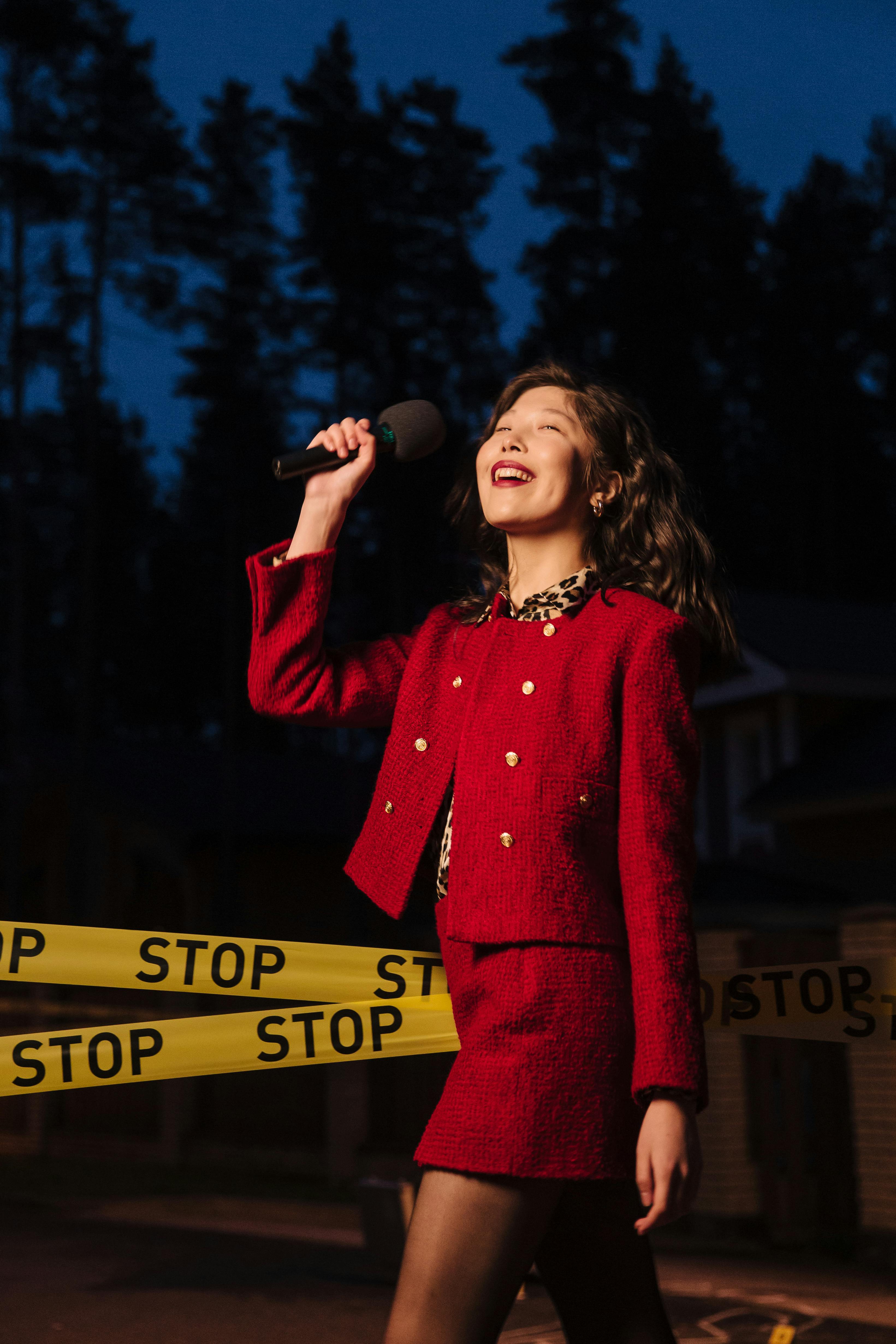 a woman in red outfit holding a microphone