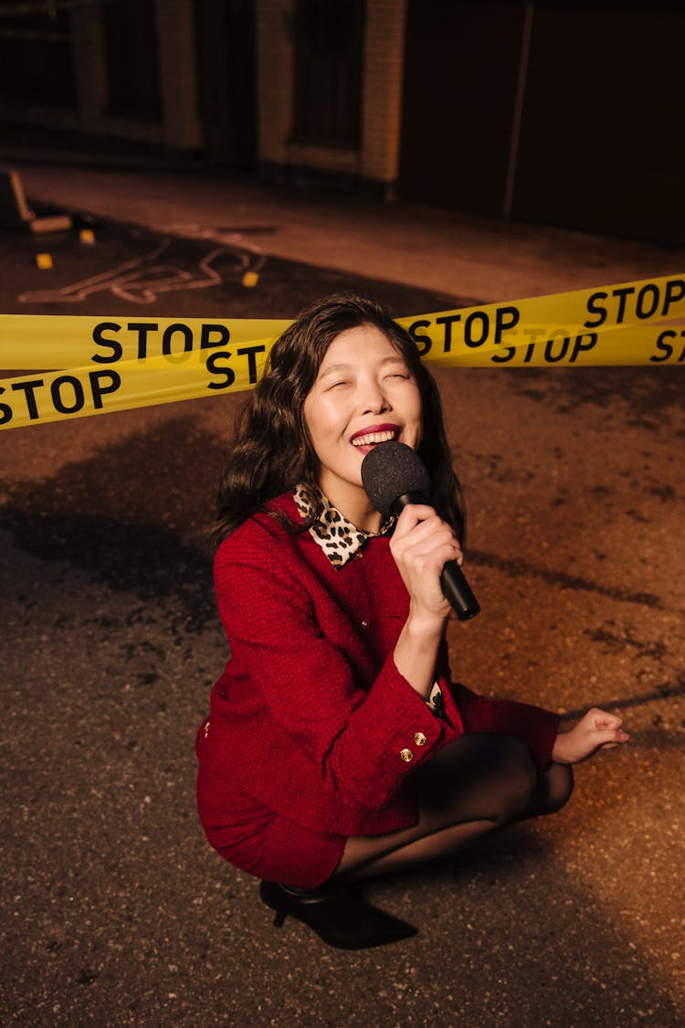 A Woman In Red Sweater Holding A Microphone