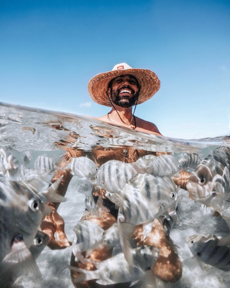 Smiling Man With Hat Over Fish Underwater