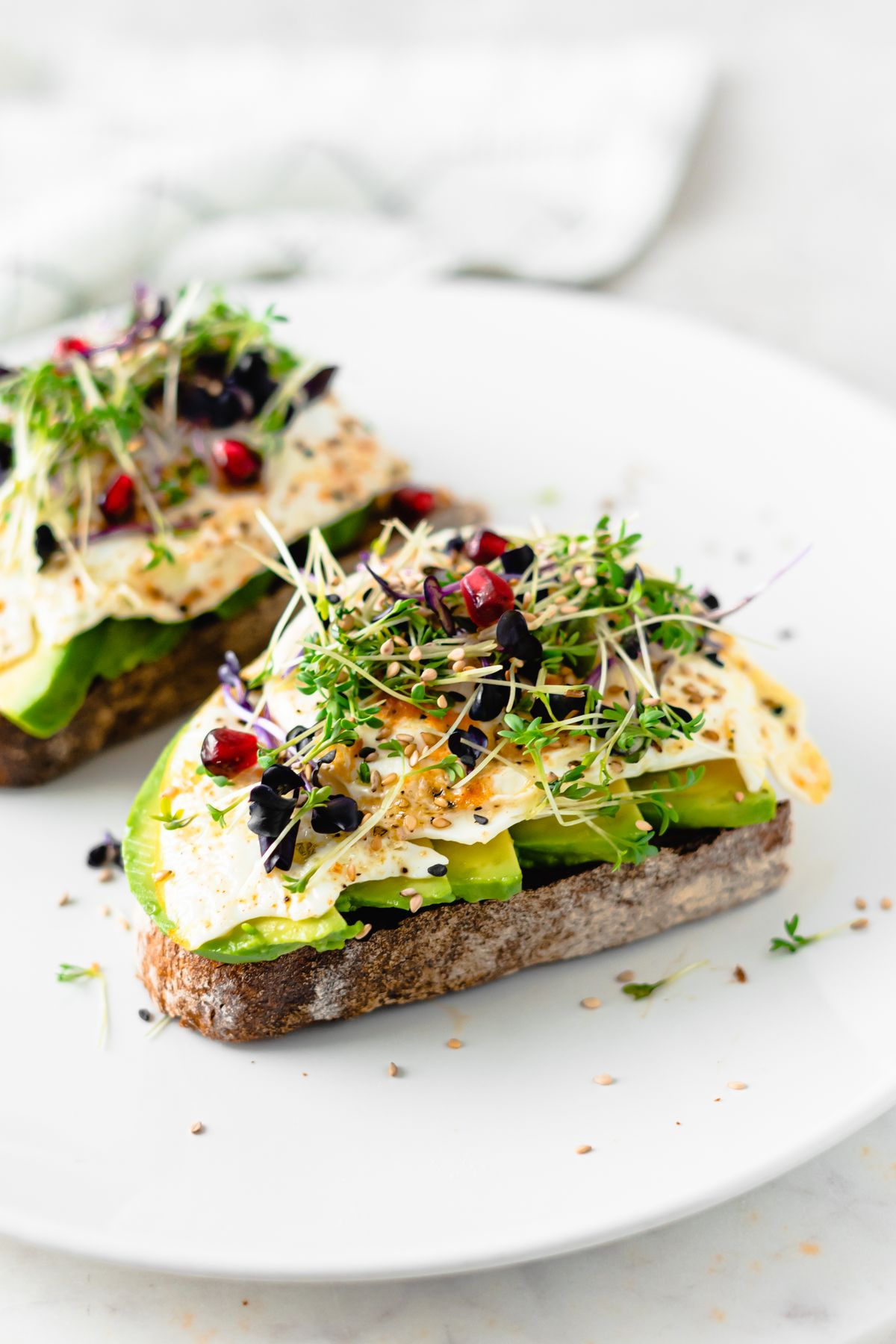 Avocado toast topped with sprouts and seeds