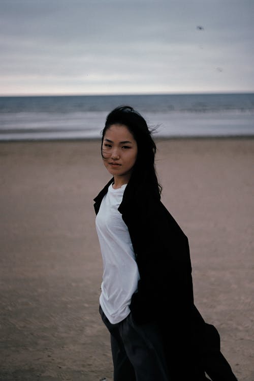 Free A Woman Wearing a Coat at the Beach Stock Photo