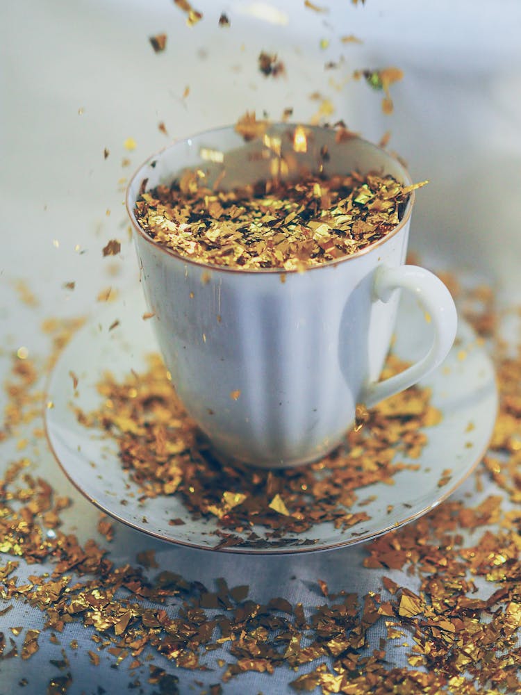 Flakes Of Gold Sprinkled On Cup Of Coffee