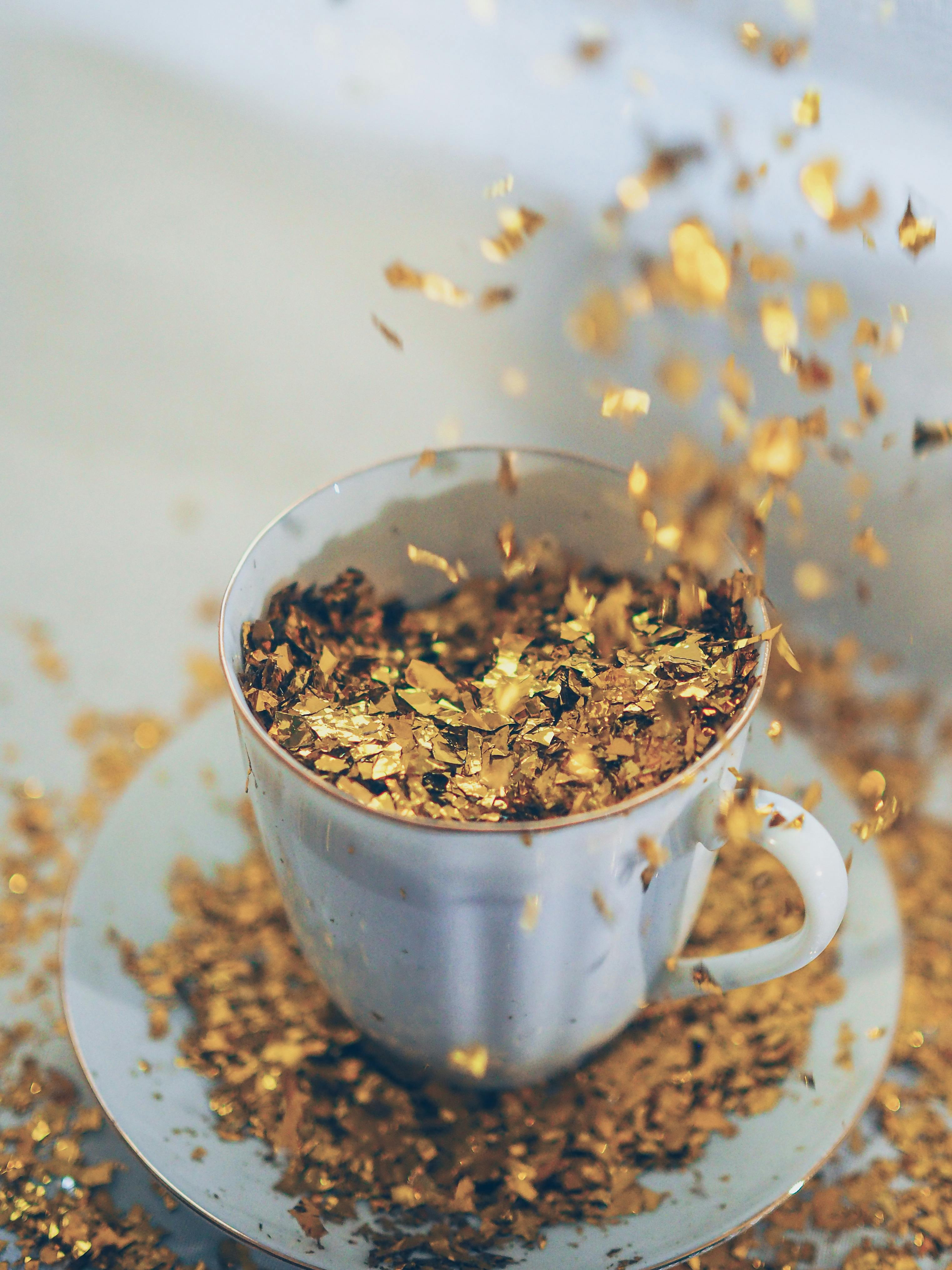 Gold Flakes Falling into Porcelain Tea Cup · Free Stock Photo