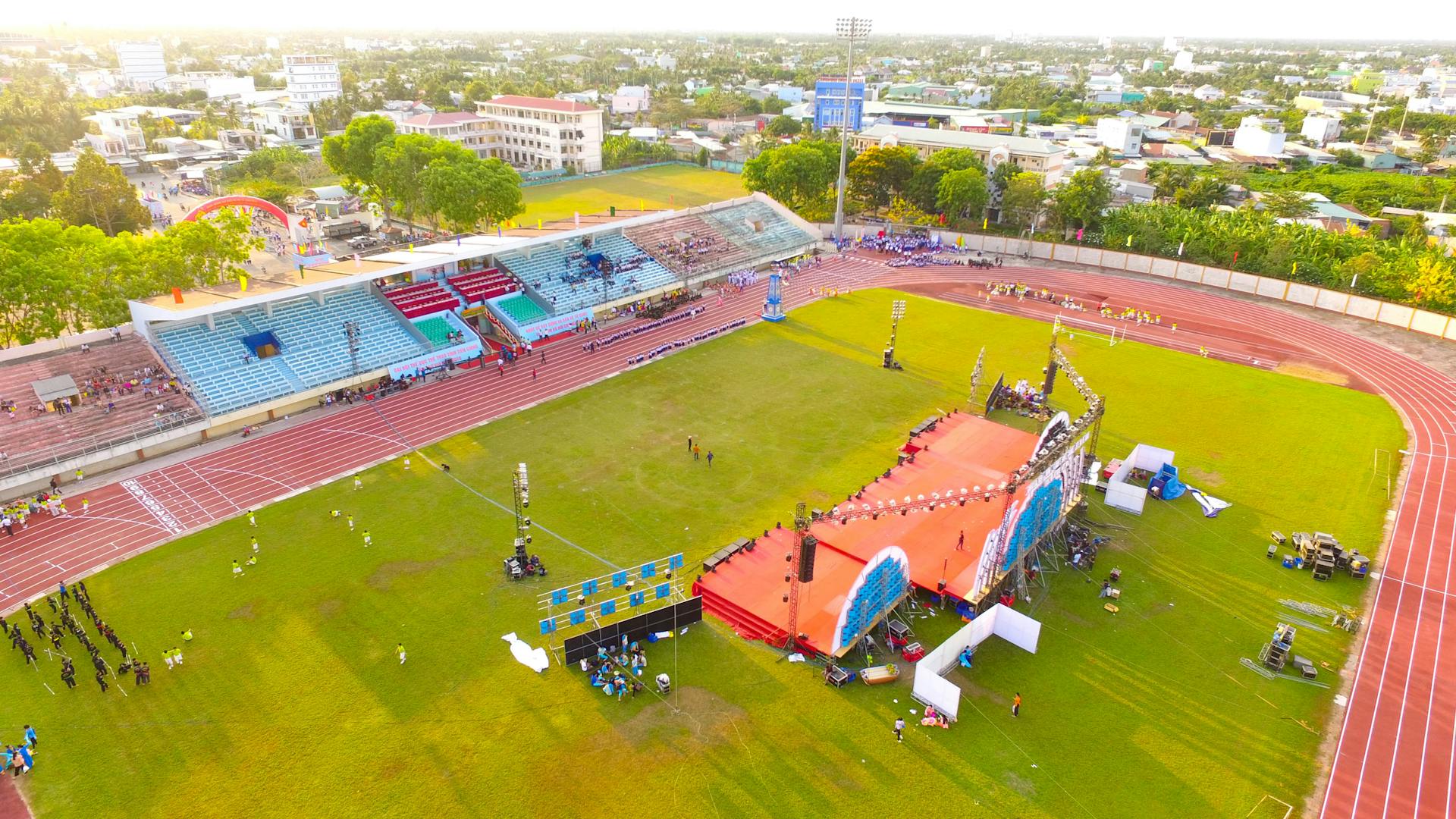 An aerial shot capturing a vibrant stadium event in Mỹ Tho, Vietnam during the day.