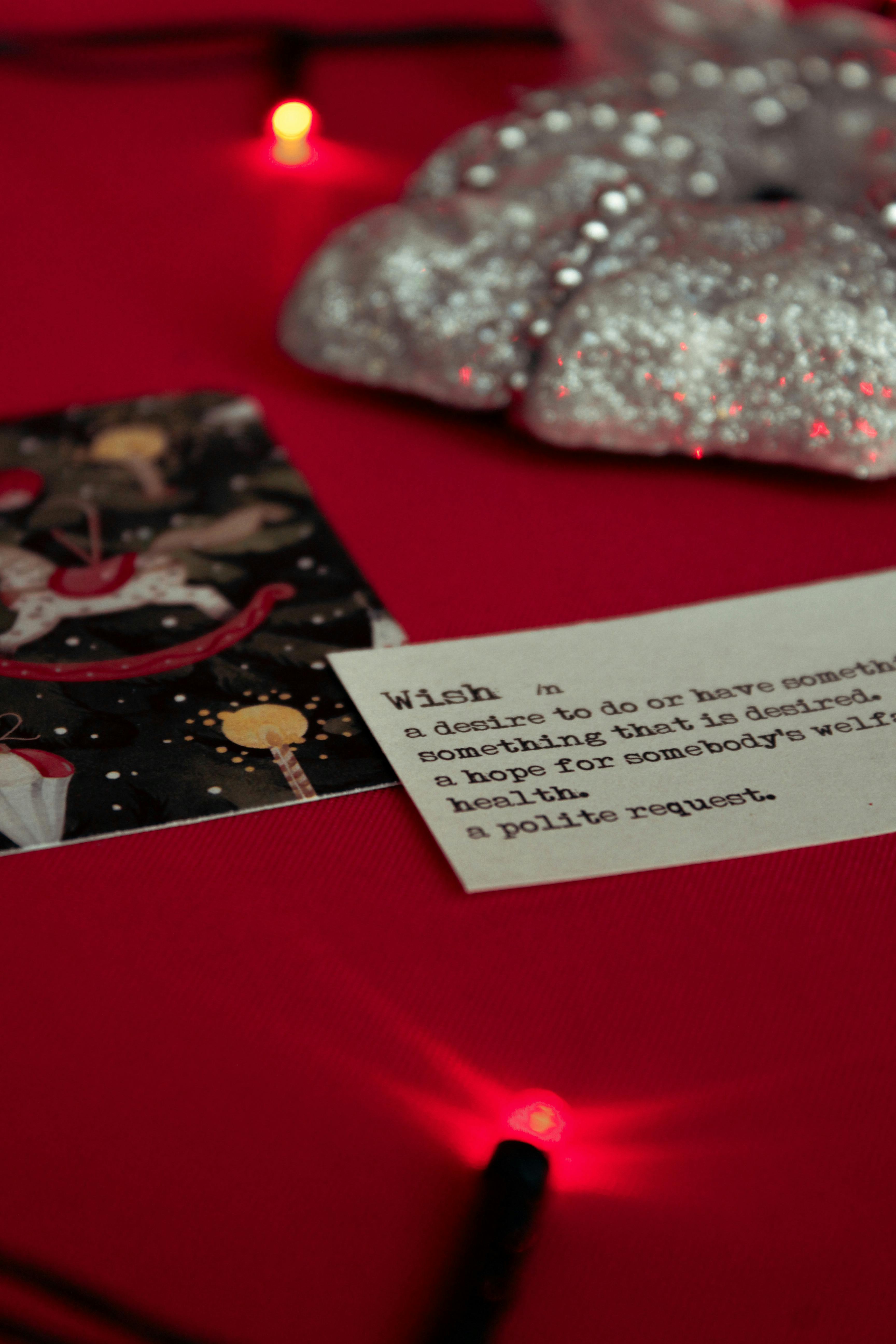 Free A cozy festive display with a holiday card, definition of wish, and shimmering decorations. Stock Photo