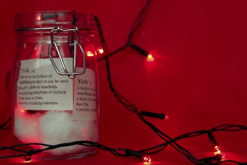 Free Glass Jar with Wishes on Paper and Christmas Lights Stock Photo