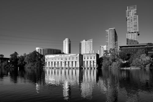 Grayscale Photo of Buildings Near Body of Water