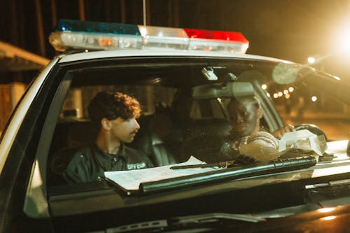 A Woman and a Woman inside the Police Car