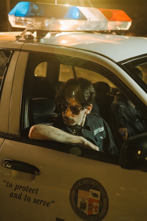 A Policeman Sitting in Police Car