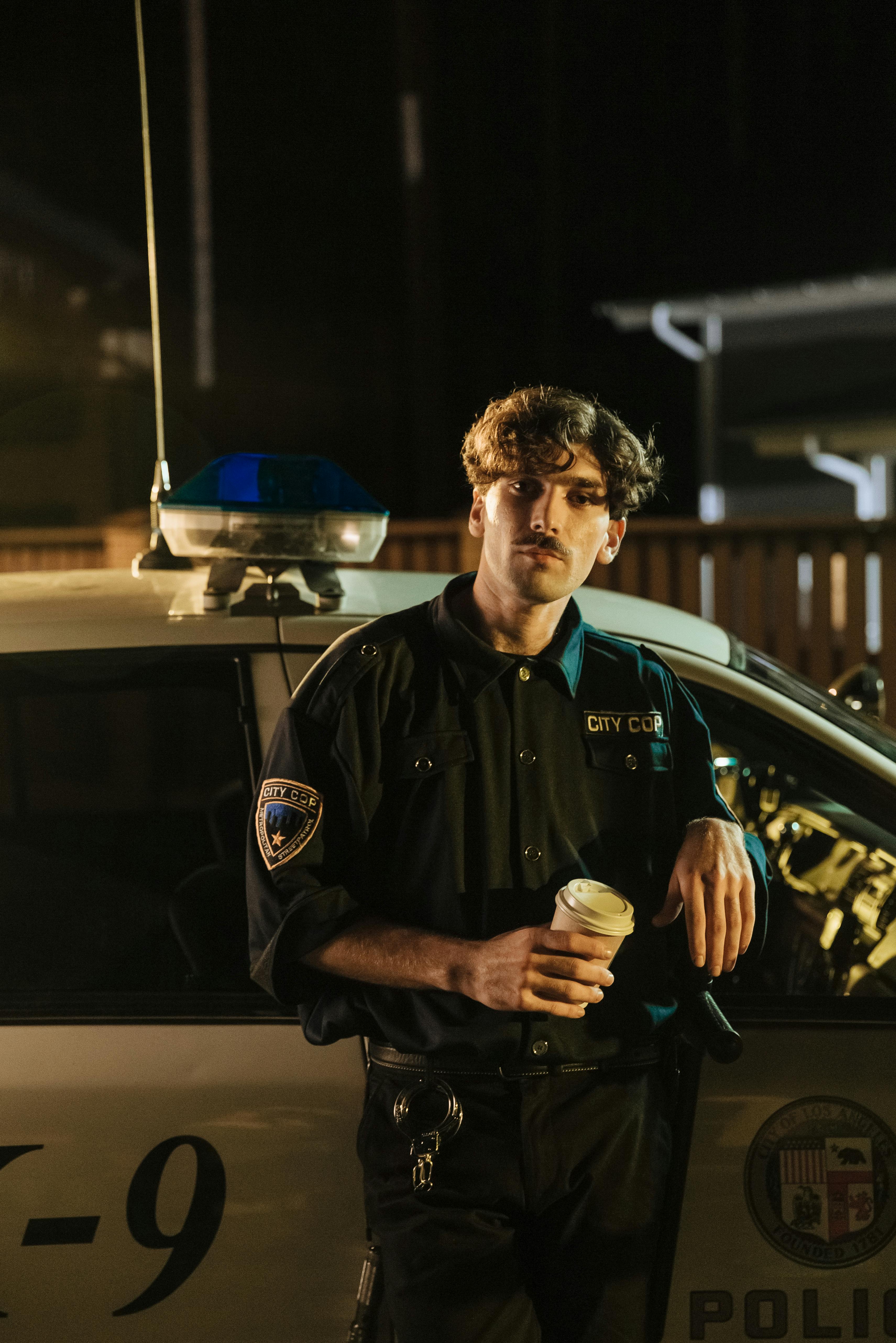 a policeman standing outside a police car