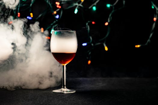 A glass of wine surrounded by smoke and colorful string lights on a dark background.