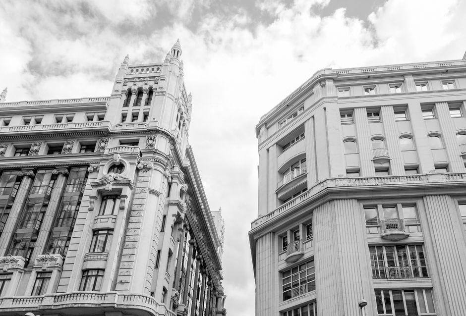 Toma desde un ángulo bajo de edificios históricos europeos que muestran la arquitectura urbana en blanco y negro.
