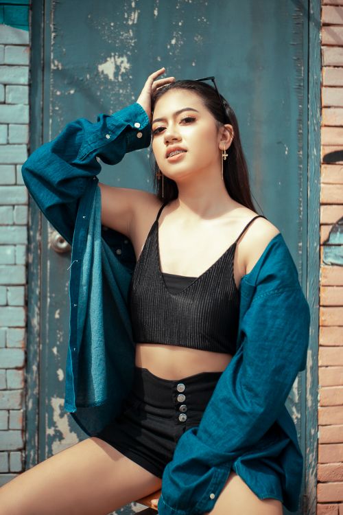 Free Stylish woman in a crop top posing outdoors in trendy fashion attire. Stock Photo