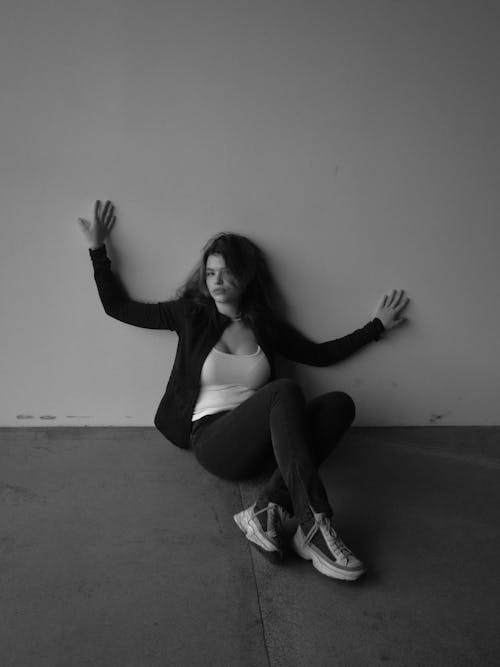 Grayscale Photo of a Woman Sitting on Floor