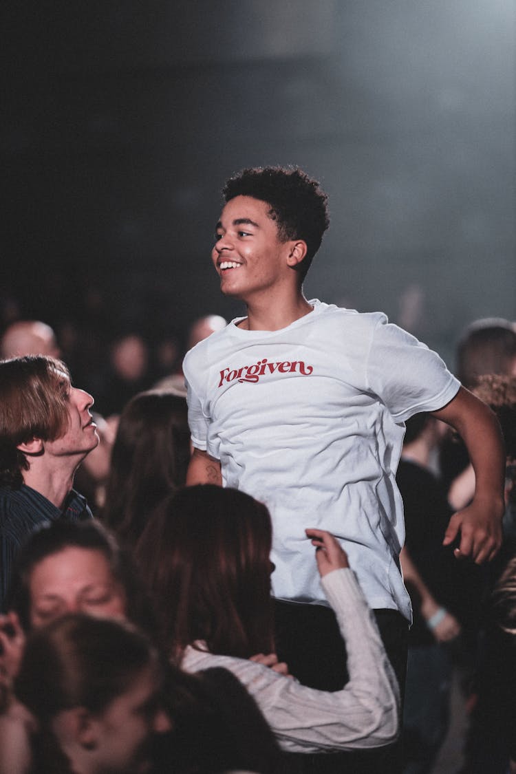 Man In White Crew Neck T-shirt Jumping In The Middle Of The Crowd