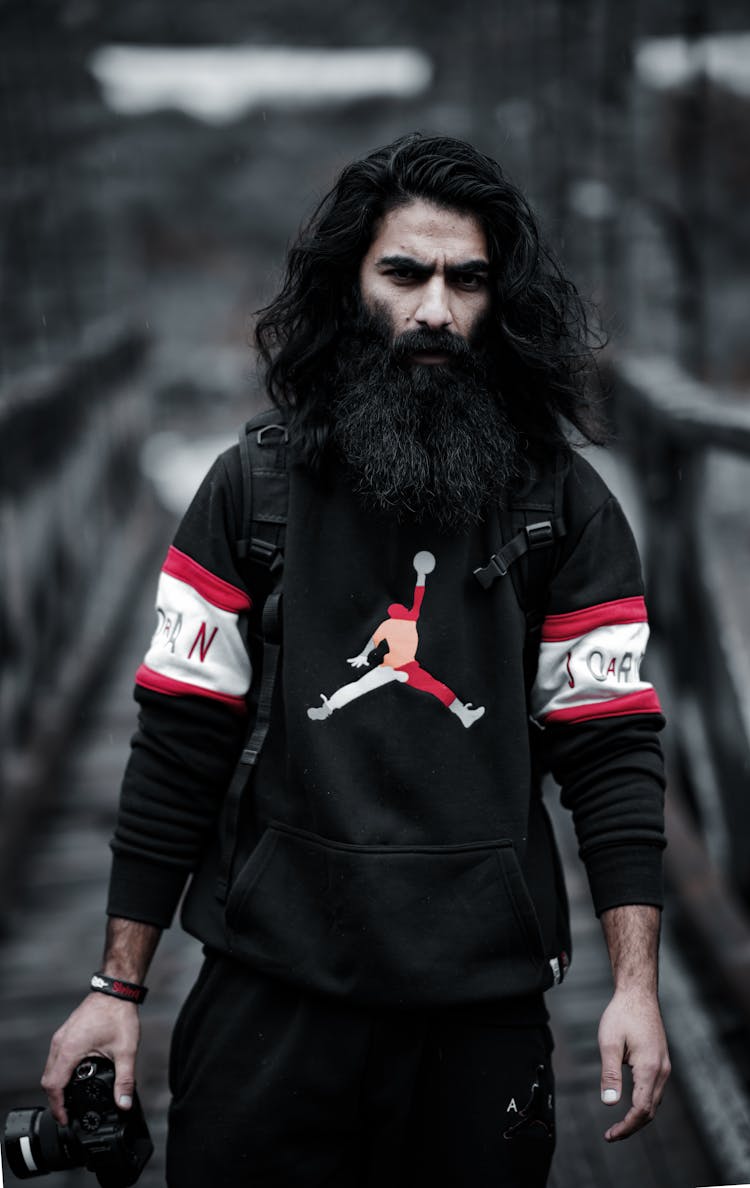 Man In Black Red And White Air Jordan Jacket Holding Camera 