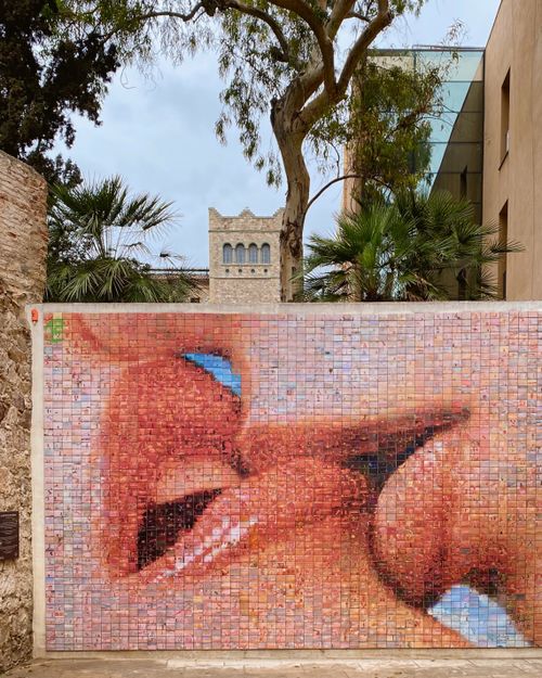 Free Captivating outdoor mural depicting a couple kissing near historic architecture. Stock Photo