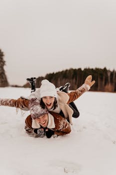 A happy couple playfully enjoys the snow, showcasing winter fun and laughter.