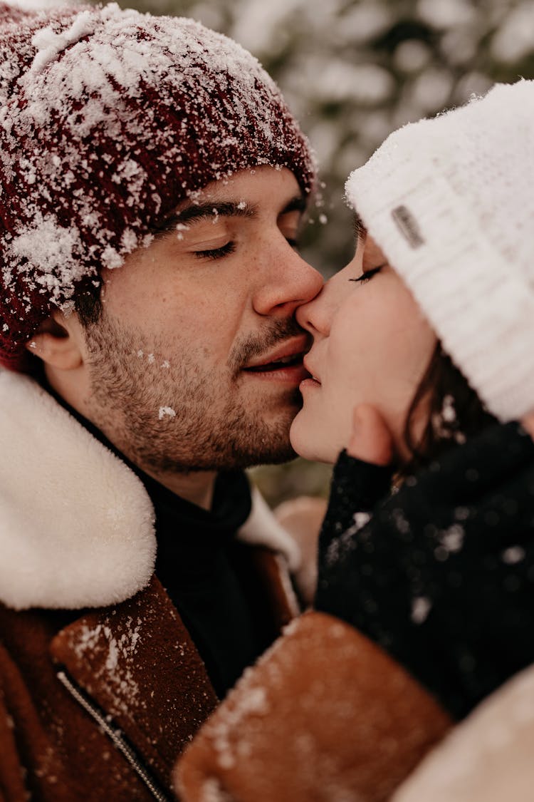 Young Couple In Winter Clothing Kissing Each Other With Closed Eyes