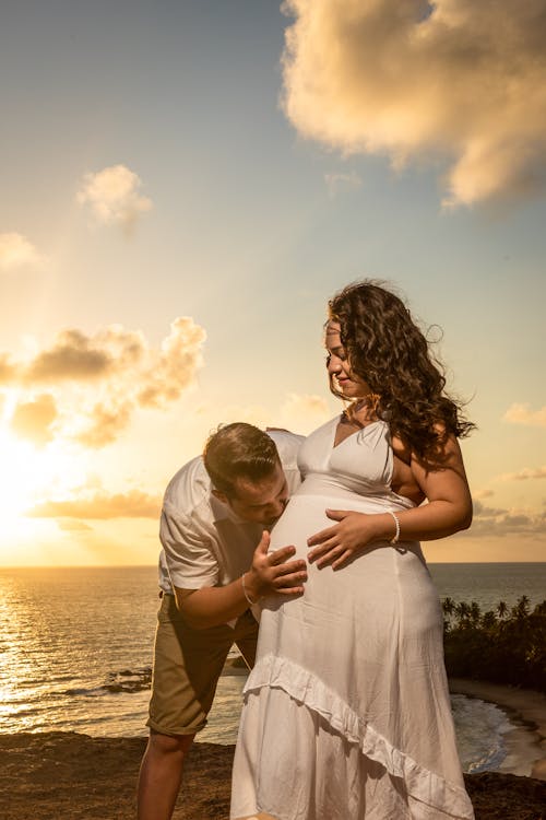 A Man Kissing Her Partner's Baby Bump