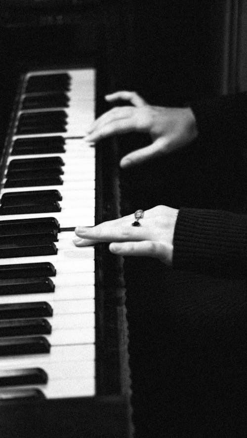 Person Playing Piano in Grayscale Photography