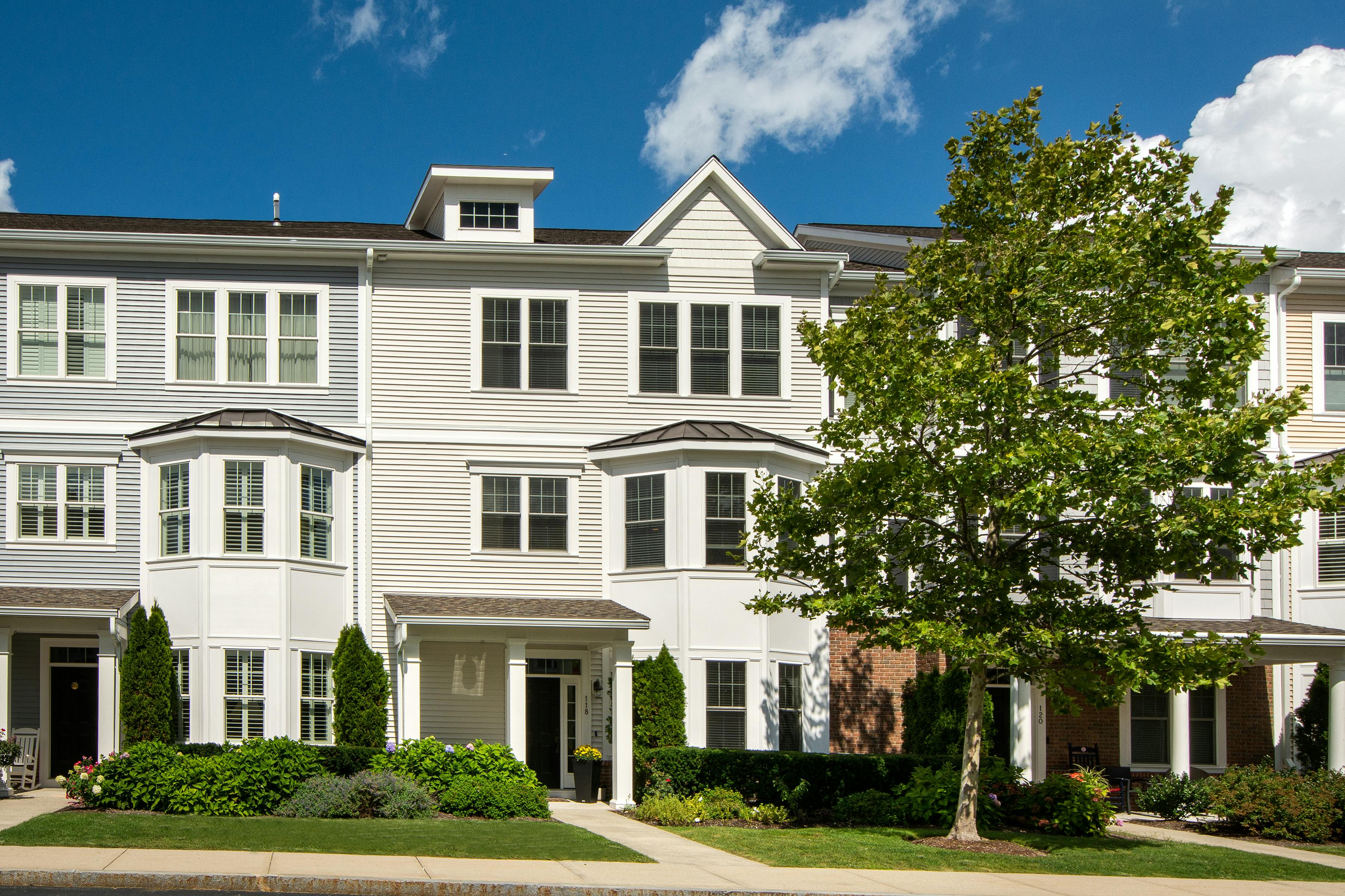A beautiful, established green lawn in a Massachusetts neighborhood, with a house in the background - fertilizer for new sod