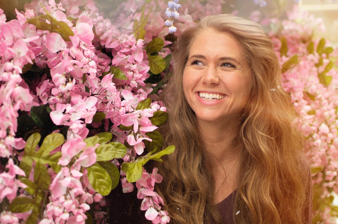 Photo of Woman Standing Beside Pink Flowers