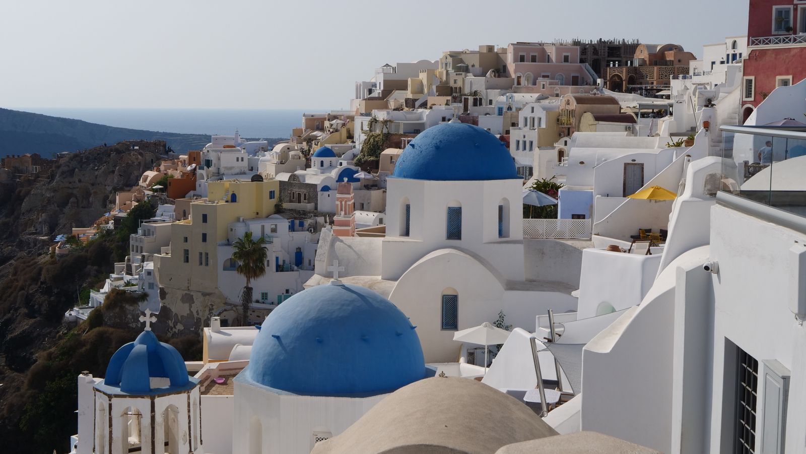 Blue-domed church and whitewashed village of Oia overlooking the Aegean